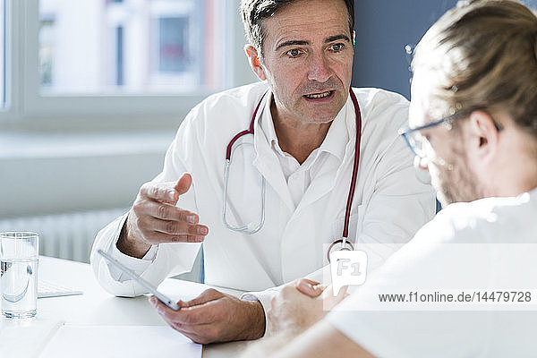 Arzt zeigt dem Patienten in medizinischer Praxis Tablette