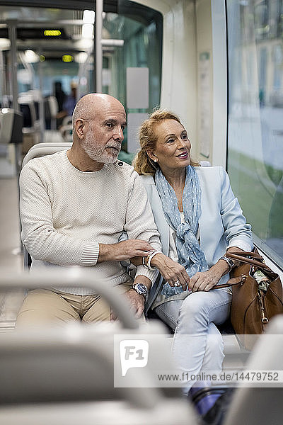 Älteres Ehepaar sitzt in einer Straßenbahn
