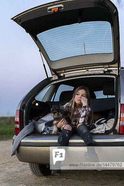Porträt eines Mädchens im geöffneten Stiefel mit ihrem Hund