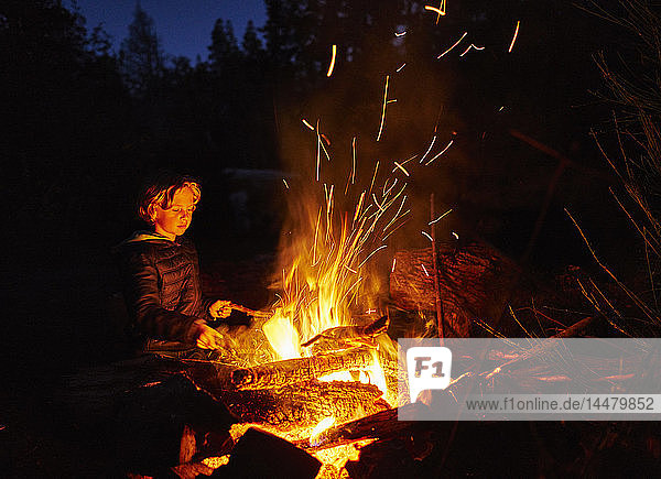 Argentinien  Patagonien  Lago Futalaufquen  Junge am nächtlichen Lagerfeuer