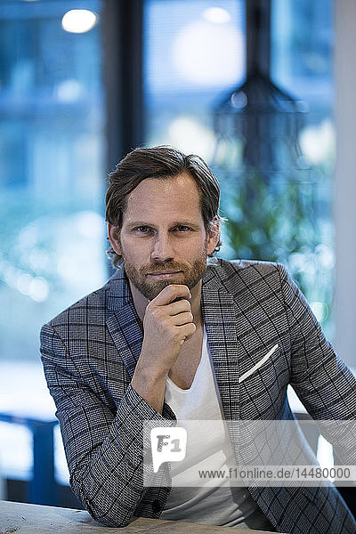 Portrait of confident smart entrepreneur in modern office lounge