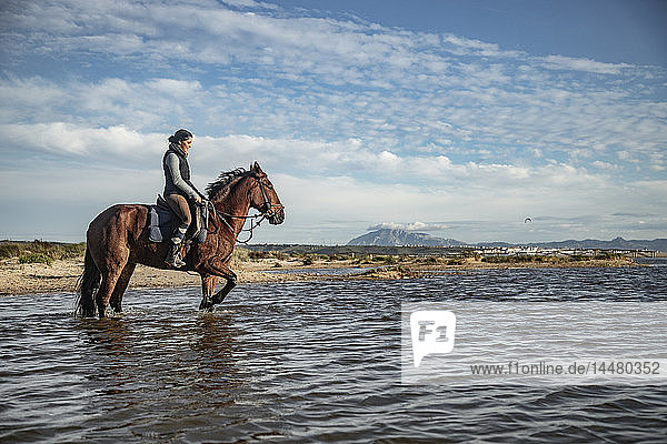 Spanien  Tarifa  Frau reitet Pferd im Meer