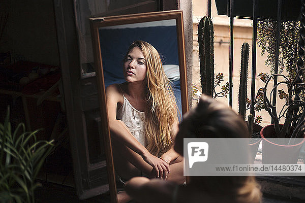 Mirror image of young woman watching herself