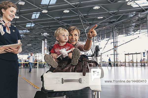 Reisende Mutter  die ihr kleines Kind am Flughafen herumführt