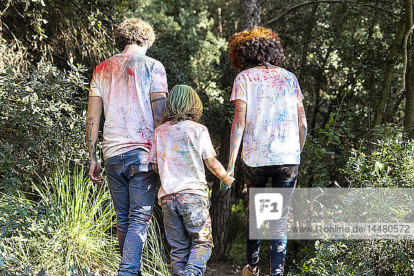 Familie im Wald  voll bunter Puderschmiere  nach der Feier des Holi  dem Fest der Farben