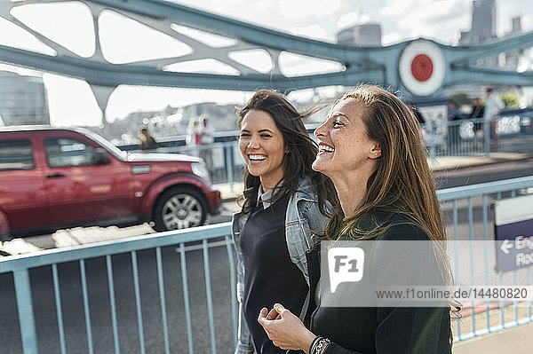 UK  London  zwei glückliche Frauen gehen auf der Tower Bridge