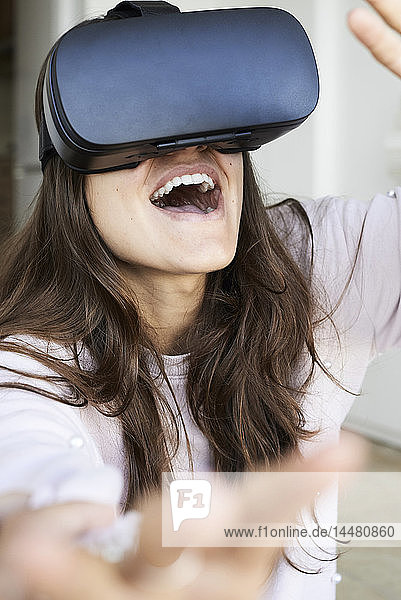 Junge Frau hat Spaß bei der Verwendung von Virtual-Reality-Headsets zu Hause