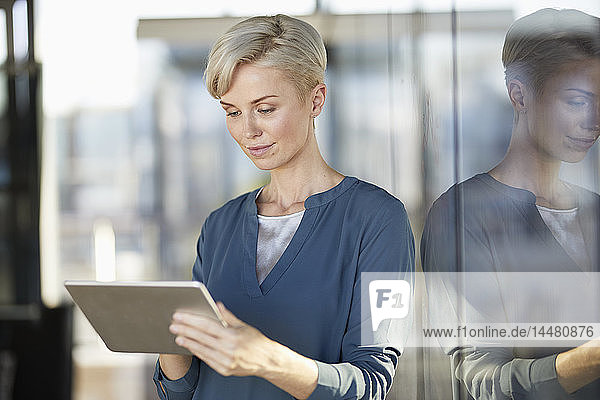 Businesswoman using tablet at the window
