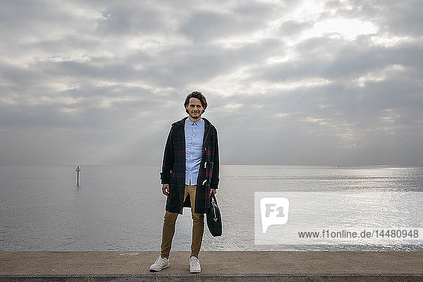 Spanien  Barcelona  Porträt eines selbstbewussten Mannes mit dem Meer im Hintergrund