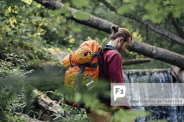 Junger Wanderer mit Rucksack im Wald