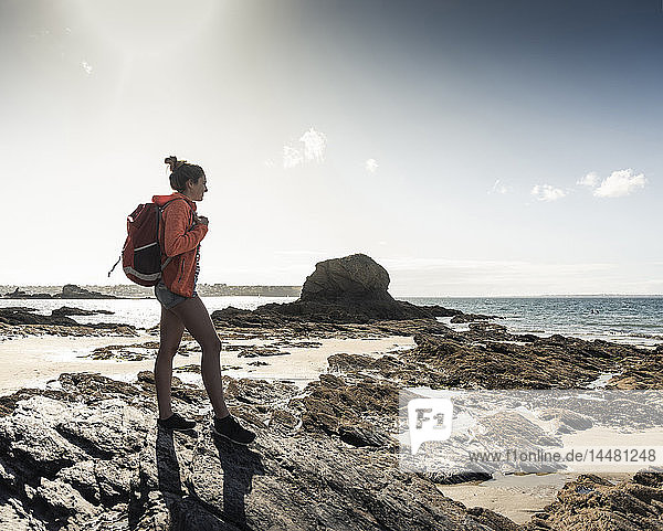 Young woman hiking on a rocky beach