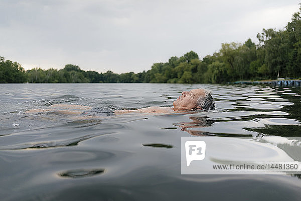 Älterer Mann schwimmt in einem See