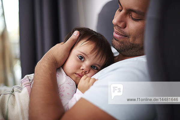 Anhänglicher Vater umarmt seine kleine Tochter zu Hause