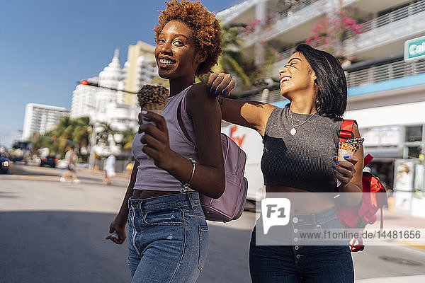 USA  Florida  Miami Beach  two happy female friends with ice cream cones in the city