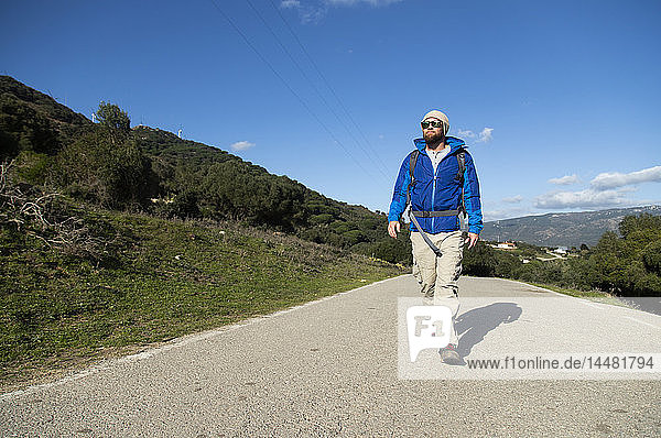 Spanien  Andalusien  Tarifa  Mann auf einer Wanderung zu Fuss auf der Strasse