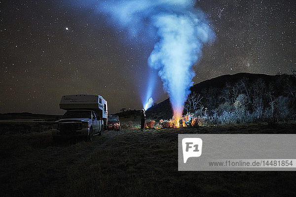 Chile  Feuerland  Lago Blanco  Lagerfeuer und Menschen im Wohnmobil unter nächtlichem Sternenhimmel