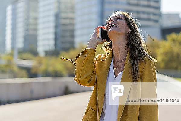 Laughing woman on cell phone in the city