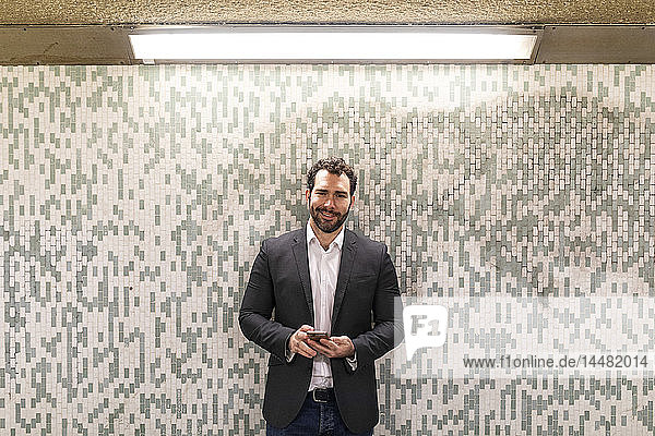 UK  London  portrait of smiling businessman in an a subway passage
