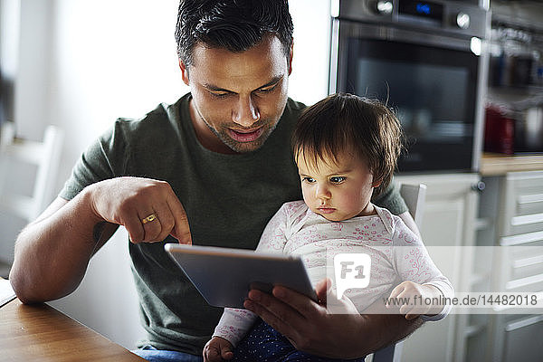 Father and baby girl using tablet at home