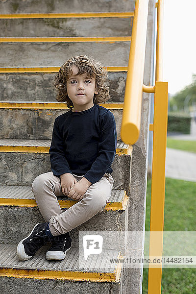 Portrait of boy sitting on stairs