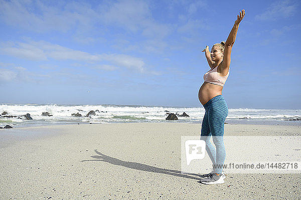 Glückliche schwangere Frau am Strand