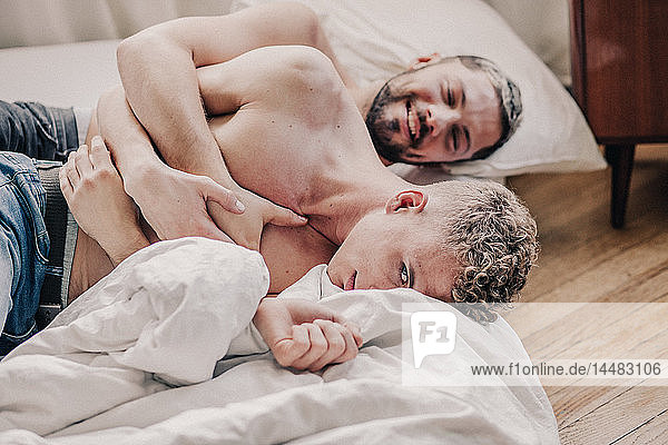 Gay couple embracing in bed