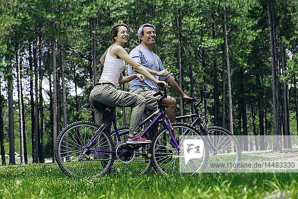 Mature couple with bicycles in forest