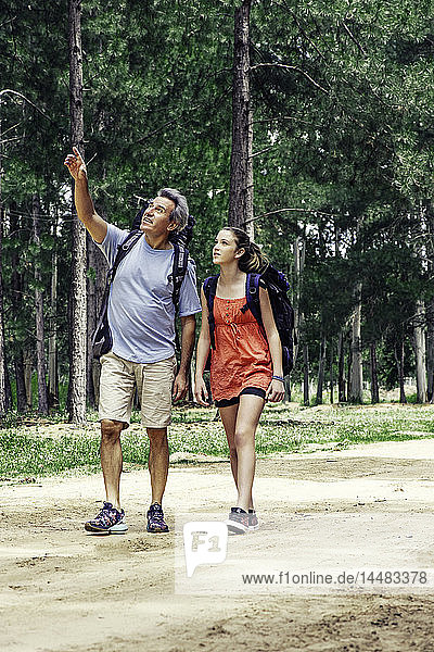 Father and daughter hiking in forest
