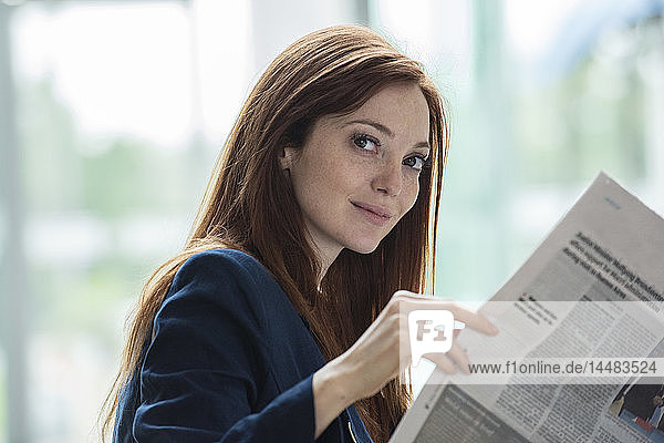 Geschäftsfrau liest Zeitung im Hotel