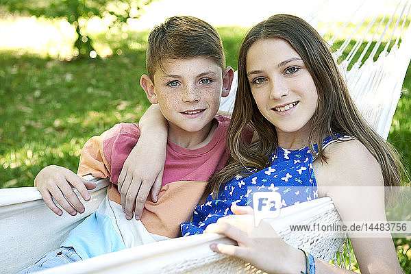 Brother and sister relaxing in a hammock