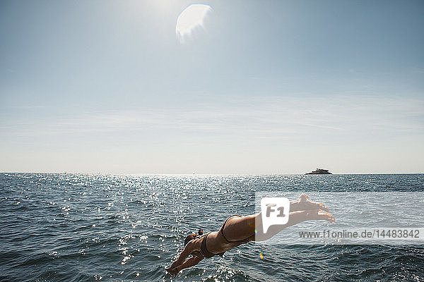 Frau taucht ins sonnige blaue Meer  Rovinj  Kroatien