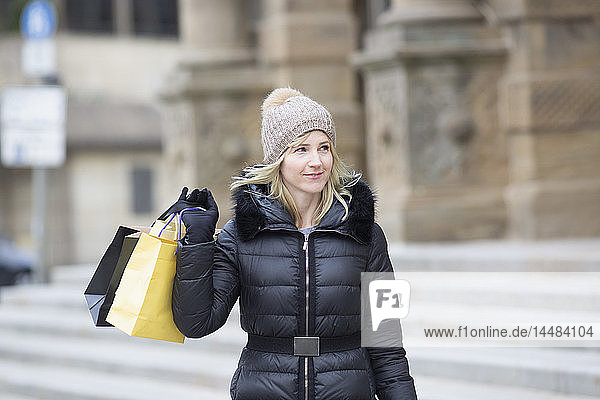 Woman in warm clothing carrying shopping bags
