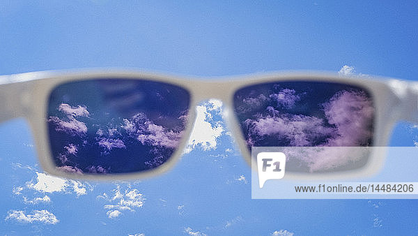 Persönliche Perspektive Sonnenbrille Blick auf sonnigen blauen Himmel mit Wolken