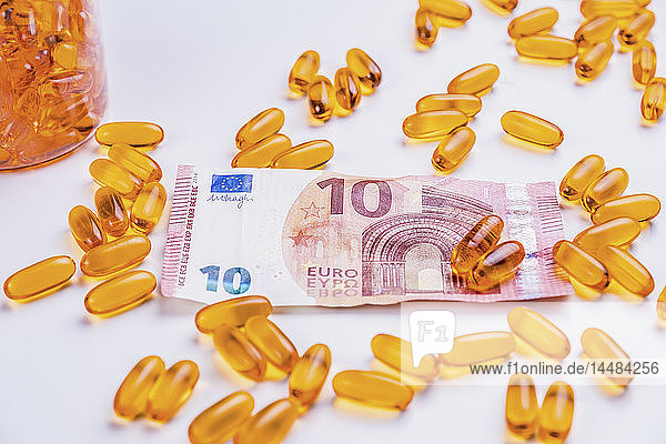 Medikamentenkapseln und Zehn-Euro-Banknote