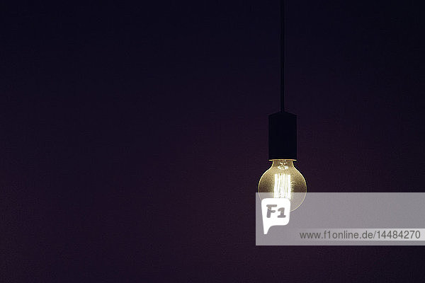 Vintage elektrische Glühbirne beleuchtet gegen schwarzen Hintergrund