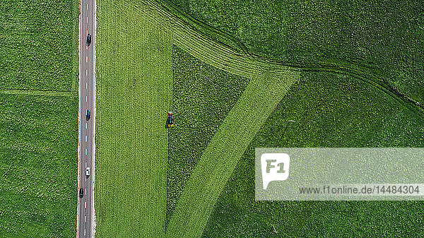 Drohne aus der Sicht eines Traktors bei der Ernte eines üppigen grünen Ackers  Südtirol  Italien