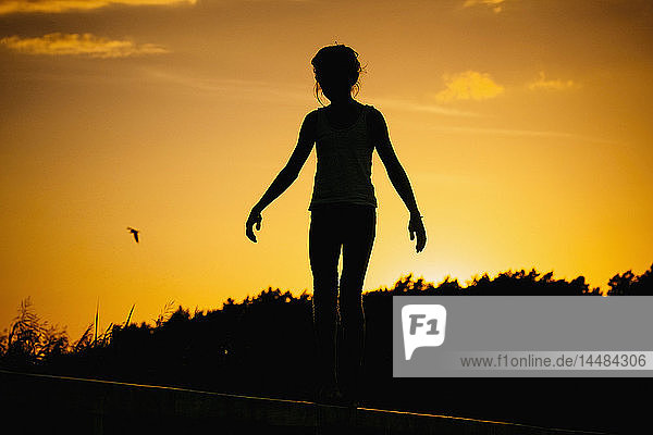 Silhouette Frau stehend gegen Sonnenuntergang Himmel
