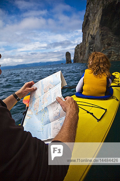 Paar erkundet Fox Island in der Resurrection Bay bei Seward  Alaska  mit Hilfe einer Karte