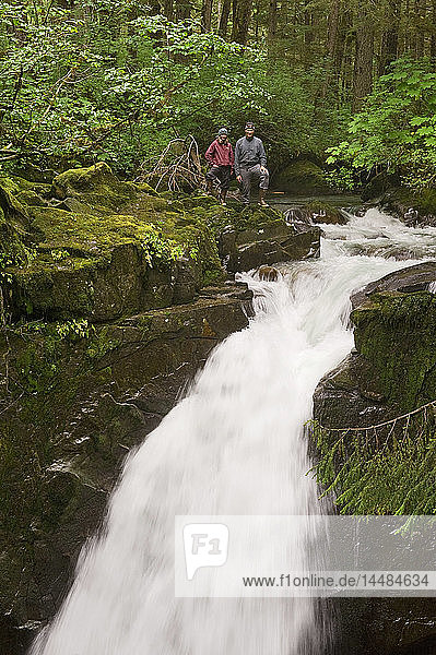 Zwei Wanderer stehen an der Spitze der Sawmill Creek Falls im Tongass National Rainforest in der Nähe von Juneau  Südost-Alaska
