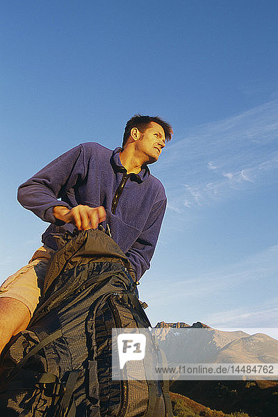 Männlicher Wanderer  der seine Ausrüstung in den Rucksack packt Chugach State Park & Mountains Southcentral Alaska Herbst