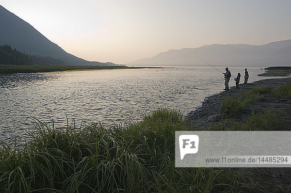 A father and his children fishing for salmon at sunset near the mouth of Resurrection Creek along the Turnagain Arm  Hope  Kenai Peninsula  Alaska Summer