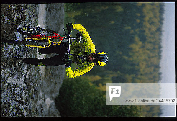 Mtn Biker trägt Fahrrad hinauf Schlamm Hügel in Radrennen Alaska Sommer Porträt