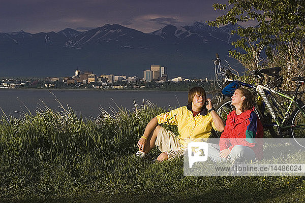 Junge und Mädchen telefonieren am Pt. Woronzof  während sie mit dem Fahrrad unterwegs sind Anchorage AK w/w/o bikes