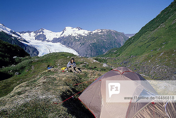 Frau zeltet und kocht am Portage Pass SC Alaska
