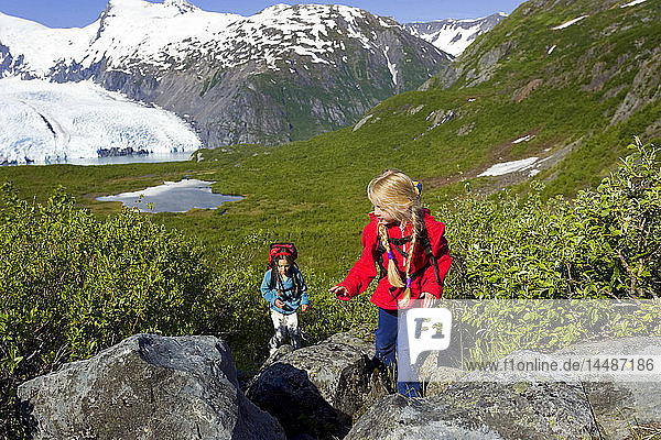 personFamily hiking together on Portage Pass Trail w/Portage Glacier Chugach Mtns & Nat Forest Alaska