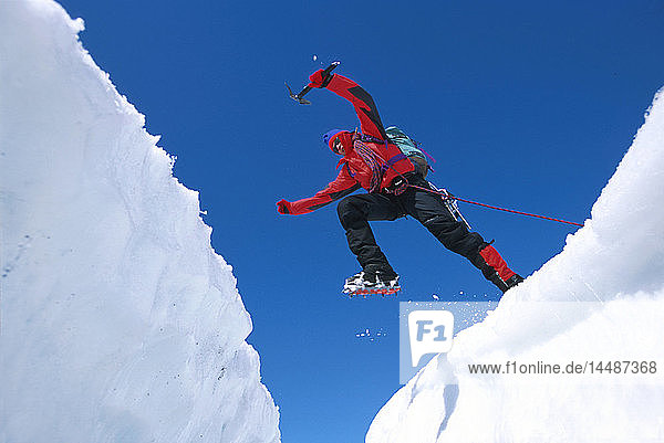 Eiskletterer springt über eine Gletscherspalte auf dem Matanuska-Gletscher SC AK