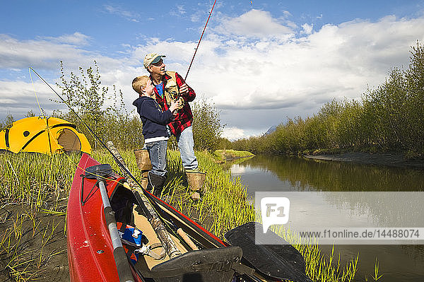 Father teaching son to fish along Rabbit Slough in Southcentral Alaska during Summer