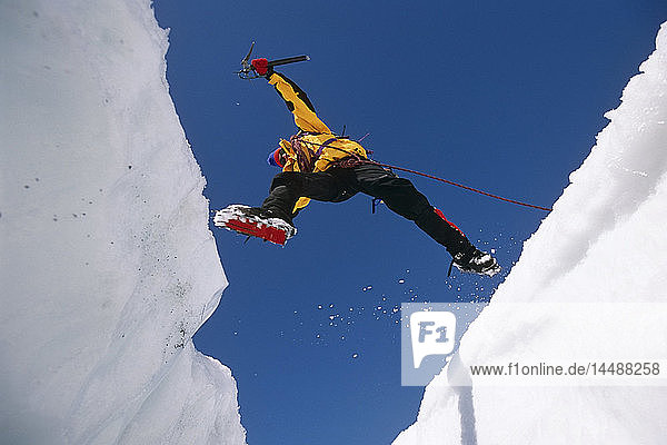 Eiskletterer springt über eine Gletscherspalte auf dem Matanuska-Gletscher SC AK
