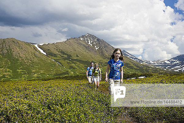 Family hiking on a trail below Flat Top Mountain  Glenn Alps area  Chugach State Park  Southcentral Alaska