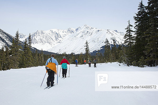 A group of friends cross country ski and snowshoe on the multi-use Moose Meadow trail near the Alyeska Hotel in Girdwood  Southcentral Alaska  Spring